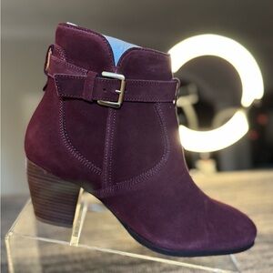 Maroon boots with buckle,‎ ankle height.